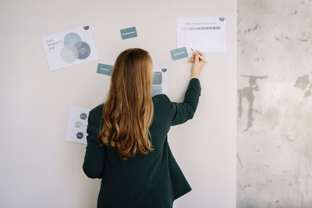 Sandra Roest staat voor een groep en begeleid een brainstorm. Op de achtergrond zie je verschillende grafieken.